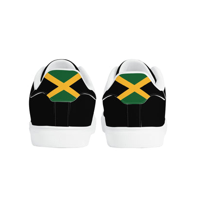All-black Jamaica flag Ackee Walkers low top sneakers with black laces, black outsole and a green and gold Jamaican flag chevron at the heel