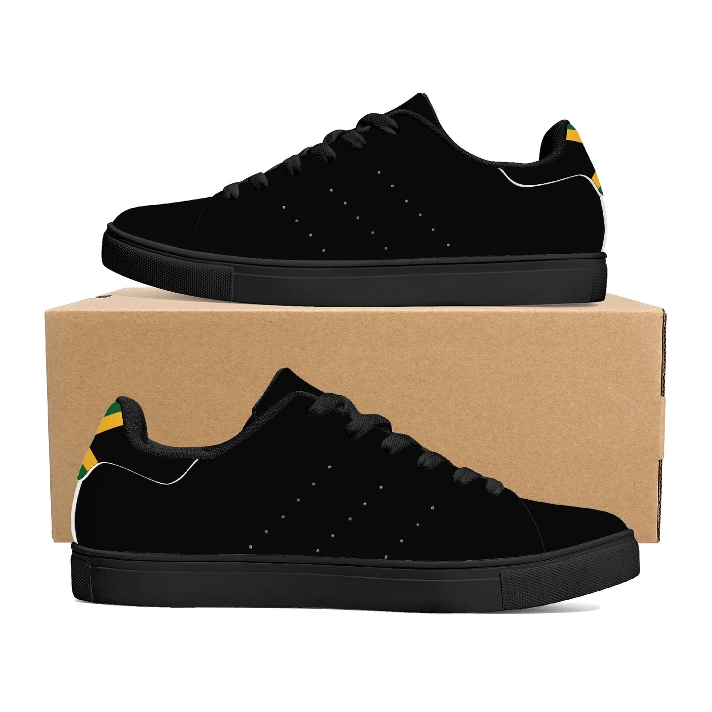 All-black Jamaica flag Ackee Walkers low top sneakers with black laces, black outsole and a green and gold Jamaican flag chevron at the heel