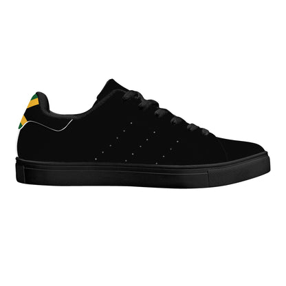 All-black Jamaica flag Ackee Walkers low top sneakers with black laces, black outsole and a green and gold Jamaican flag chevron at the heel
