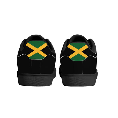All-black Jamaica flag Ackee Walkers low top sneakers with black laces, black outsole and a green and gold Jamaican flag chevron at the heel