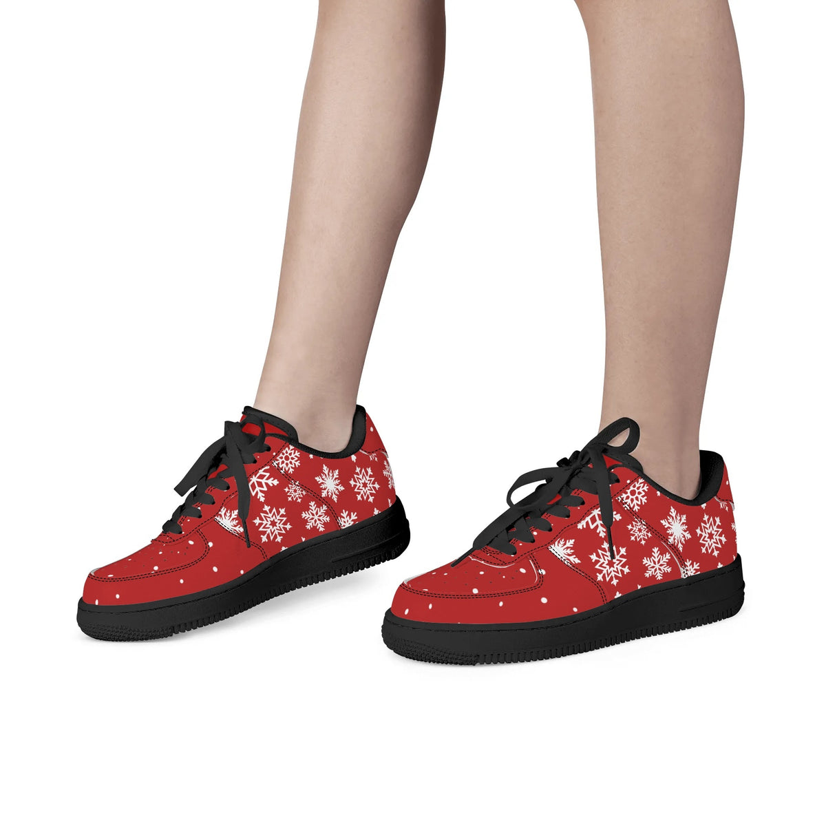 Red Christmas snowflake low tops with black laces and black soles, shown on feet