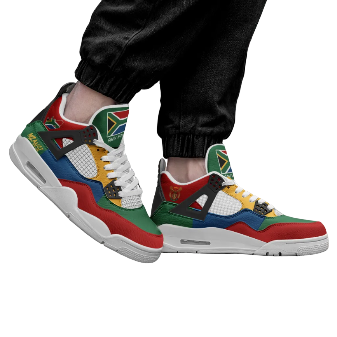 A person wearing black jogger-style pants and multicolor Air Jordan 4 sneakers with a South African flag-inspired color-blocked design.