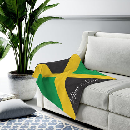 Personalised Jamaica flag throw spread across a sofa seat with the name reading along the edge.